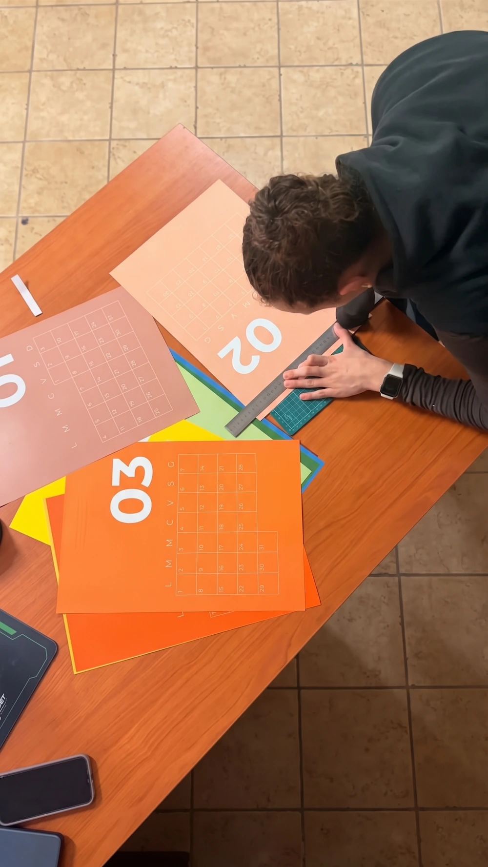 Maria Pia Surfaro taglia con la taglierina il calendario stampato, vista dall'alto